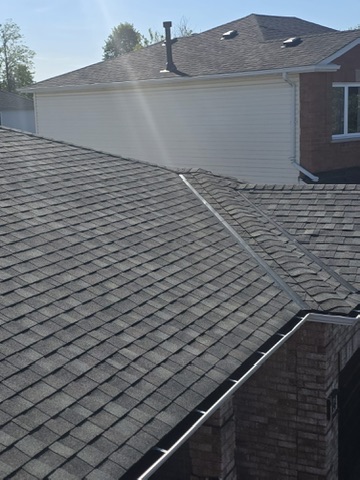 Close-up of finished grey shingle roof with skylight by 905 Roofing Inc. in Durham Region and the GTA