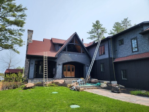 Large cottage roofing project with ladders and crew access by 905 Roofing Inc. in Durham Region and the GTA