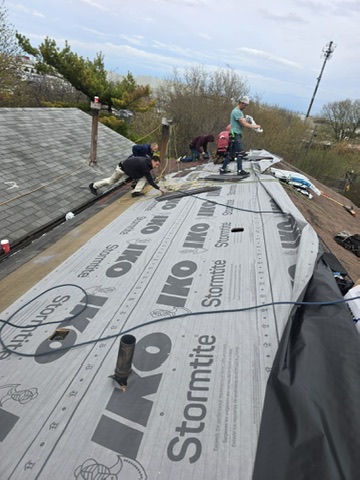 Roofer fastening shingles on steep gable roof by 905 Roofing Inc. in Durham Region and the GTA