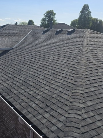Professional roofer installing new architectural shingles on a residential home