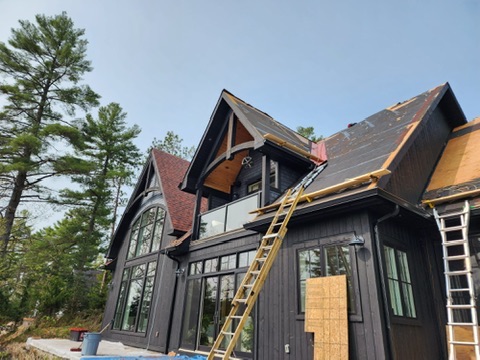 Cottage roof replacement with exposed deck and ladders by 905 Roofing Inc. in Durham Region and the GTA