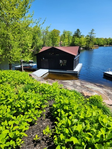 Boathouse roof beside lake with red shingles by 905 Roofing Inc. in Durham Region and the GTA