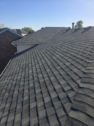 Sunlit residential shingle roof with chimney and vents by 905 Roofing Inc. in Durham Region and the GTA